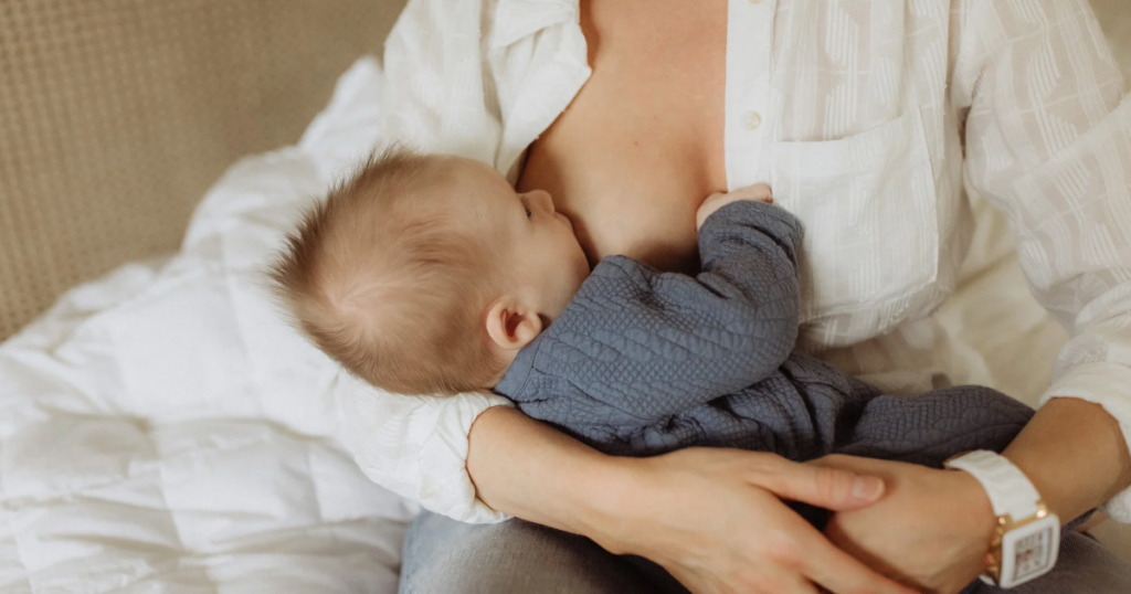 Mother breastfeeding her newborn with a deep latch to reduce nipple pain and improve comfort